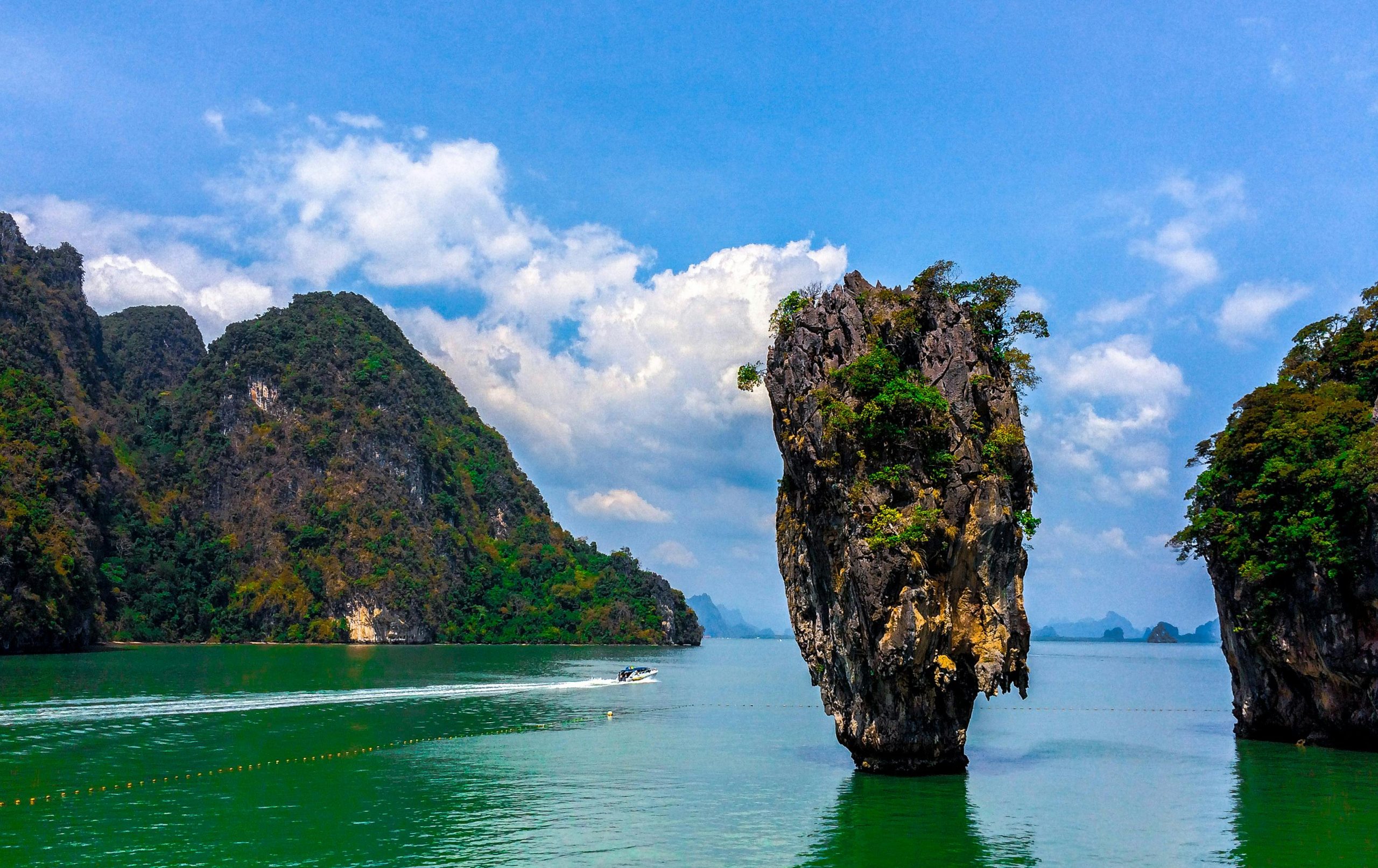 Stunning rock formations at James Bond Island, Thailand with vibrant green waters and blue skies.